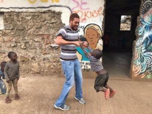Khalil Griffith plays with children during his first trip to Kenya, while implementing youth curriculum to promote healthy masculinity in the community.